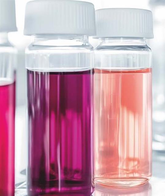 Analytical screw-cap vials with colored samples on a lab shelf